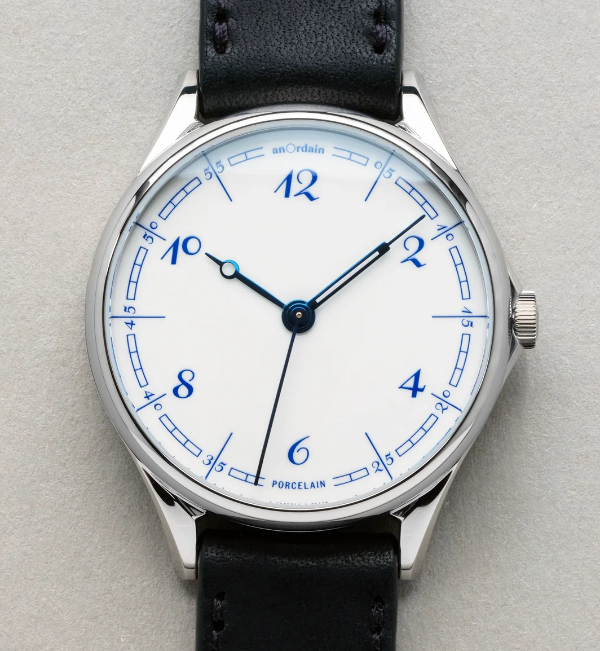 White watch face with Delft Blue numbers and markings, with blue hands created from heated steel